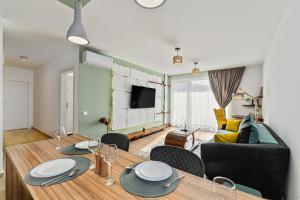 a living room with a dining table and a couch at B-Holiday Luxury Apartments Urban Plaza in Braşov