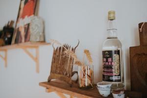 uma garrafa de álcool sentada numa prateleira de madeira em 島中大厝 em Jinhu