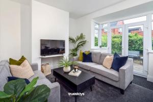 ein Wohnzimmer mit einem Sofa und einem Tisch in der Unterkunft NEW Poplar House - Stunning 4 Bedroom House in Stoke-on-Trent in Newcastle under Lyme
