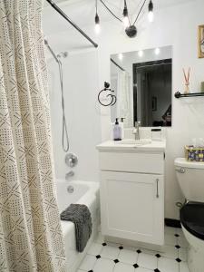 a bathroom with a shower curtain and a sink and a toilet at Cozy 1BR with Free Parking Downtown Conv Center in Seattle