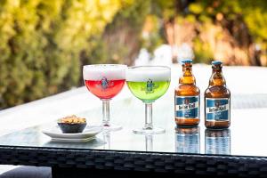 two glasses and two bottles of beer on a table at Pestana Berlin Tiergarten in Berlin