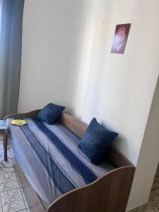 Bett in einem Zimmer mit blauen Kissen darauf in der Unterkunft Apartamento com piscina 1 quarto de até 6 pessoas - Guarujá in Guarujá