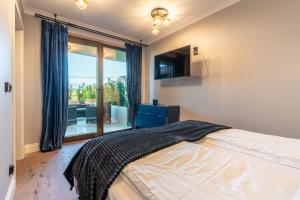 sypialnia z łóżkiem i dużym oknem w obiekcie Góralski Resort Pool & SPA w mieście Białka Tatrzanska