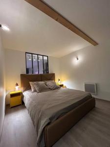 een slaapkamer met een groot bed en een raam bij Hypercentre * Pop * Calme - Le Grand Rétro in Pontarlier