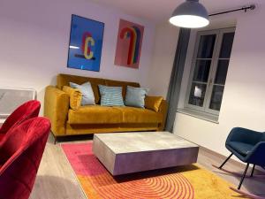 een woonkamer met een bank en een salontafel bij Hypercentre * Pop * Calme - Le Grand Rétro in Pontarlier
