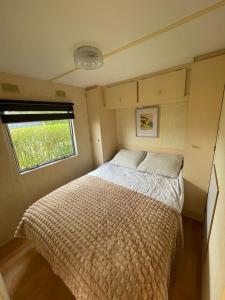 Łóżko w małym pokoju z oknem w obiekcie Perenhof 6 w mieście Oostvoorne