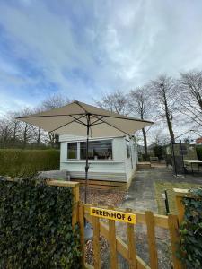 una pequeña casa con un paraguas delante en Perenhof 6, en Oostvoorne