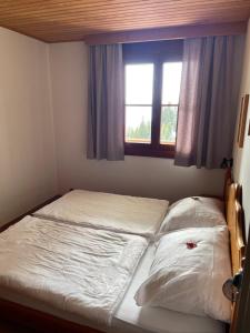 a bed with two pillows in a bedroom with a window at Apartment sunny mountains Gerlitzen in Deutschberg