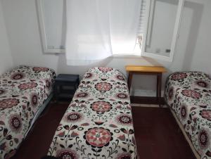 dwa łóżka w pokoju z dwoma oknami w obiekcie Almirante Brown 49 w mieście Mar de Ajó