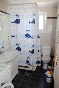 a bathroom with a shower curtain with dolphins on it at Olympia's Sea Resort 1 in Mourteri