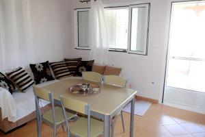 a living room with a table and chairs and a couch at Olympia's Sea Resort 1 in Mourteri +22 photos