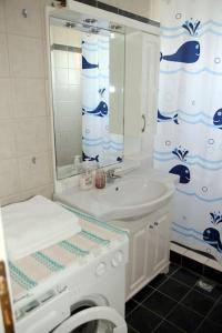 a white bathroom with a sink and a toilet at Olympia's Sea Resort 1 in Mourteri