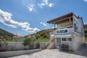a white house with a hill in the background at Olympia's Sea Resort 1 in Mourteri