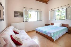 a bedroom with two beds and two windows at Olympia's Sea Resort 1 in Mourteri