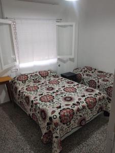 a bedroom with two beds with a floral bedspread at Almirante Brown 49 in Mar de Ajó