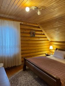 a bedroom with a bed and a wooden wall at Cottage PolyaNitsa окремий котедж з каміном in Bukovel +109 photos