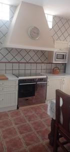 a kitchen with a stove and a microwave at Pandora Casa Rural en Madrigueras in Albacete