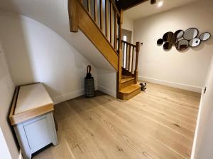 a hallway with a staircase and wooden floors at Laurel Cottage in Sandown