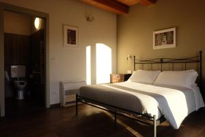 een slaapkamer met een groot bed met witte kussens bij Agriturismo Ceriano in Modigliana