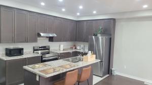 a kitchen with wooden cabinets and a stainless steel refrigerator at Modern 3 bedroom home in Brampton in Brampton