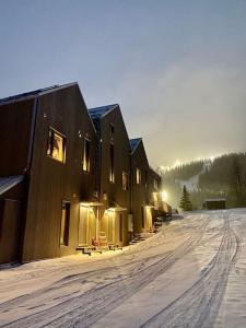 een rij huizen in de sneeuw met de zon die schijnt bij Ski in/ski out i Funäsdalen! Nybyggt i toppenläge in Funäsdalen
