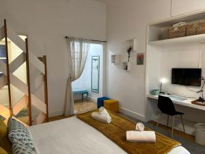 a room with a bed and a desk with a computer at Alojamentos Vista Mar-Luisa Todi in Setúbal