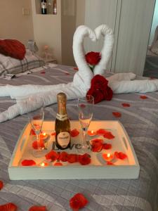 a tray with a bottle of champagne and roses on a bed at B&B La Penisola in Gragnano