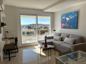 a living room with a couch and a large window at Mediterraneo Sitges in Sitges