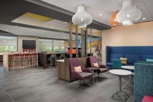 a waiting room with chairs and tables and a bar at Tru By Hilton San Antonio North in San Antonio