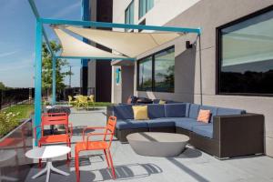 a patio with a blue couch and orange chairs at Tru By Hilton San Antonio North in San Antonio