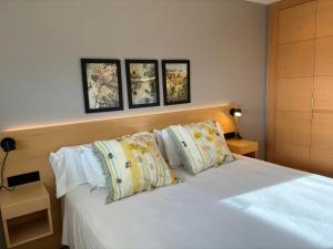 a bedroom with a white bed with four pillows at Mediterraneo Sitges in Sitges