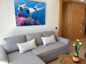 a living room with a couch and a painting on the wall at Mediterraneo Sitges in Sitges