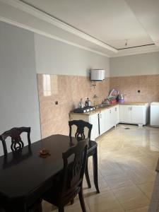 uma cozinha com mesa e cadeiras num quarto em Appartement 5 en 2eme étage em Oujda