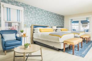 a bedroom with a bed and a blue chair at Danfords Hotel & Marina in Port Jefferson Station