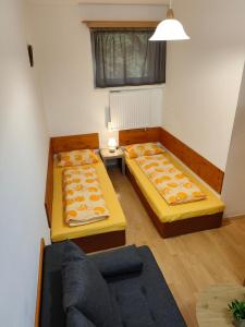 uma sala de estar com duas camas e um sofá em Apartmán LUCKA em Donovaly