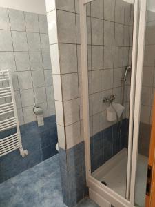 um chuveiro com uma porta de vidro na casa de banho em Apartmán LUCKA em Donovaly