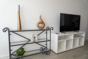a living room with a tv on a white shelf at Nordik Apartments Urban - Bellavista "Moskenes" in Málaga