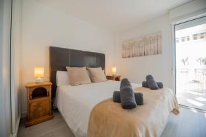 2 letti in una camera da letto con 2 asciugamani grigi di Nordik Apartments Urban - Bellavista "Moskenes" a Málaga