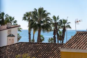 a view of palm trees and the ocean from a building at Nordik Apartments Urban - Bellavista "Moskenes" in Málaga