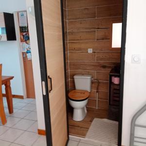 a bathroom with a toilet with a wooden wall at Rêves de vie Studio avec terrasse le Figuerolles in Cassis