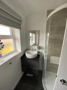 a bathroom with a sink and a shower at The Marlene - Lovely 3-Bed Home - Free WIFI & Parking - Short or Long Stays in Burton upon Trent
