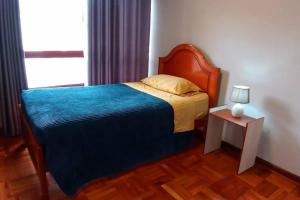 - une chambre avec un lit et une table avec une lampe dans l'établissement Estudio a estrenar en Miraflores, à La Paz