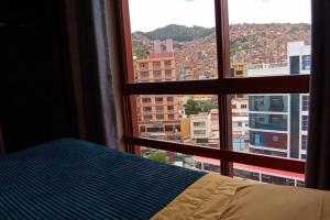 a bedroom with a view of a city from a window at Estudio a estrenar en Miraflores in La Paz