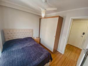 a bedroom with a blue bed and a door at Lindo Apartamento - 15 min de Pinheiros in Osasco