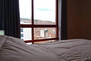 a bed in front of a window with a view at Estudio a estrenar en Miraflores in La Paz