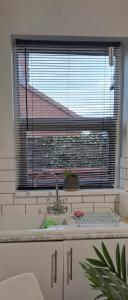 een keuken met een wastafel en een raam bij Herbert - Duplex Relocations in Mexborough