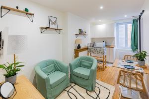 een woonkamer met 2 stoelen en een tafel bij Owl Right - C La Chouette in Dijon