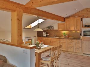 a kitchen with wooden cabinets and a table with chairs at Sotterhof - Chiemgau Karte in Inzell