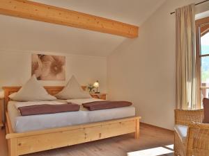 ein Schlafzimmer mit einem Bett in einem Zimmer mit einem Fenster in der Unterkunft Sotterhof - Chiemgau Karte in Inzell