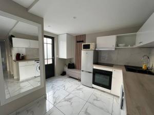 a kitchen with white appliances and a large tile floor at Maison MAIA Paris-Creteil in Créteil